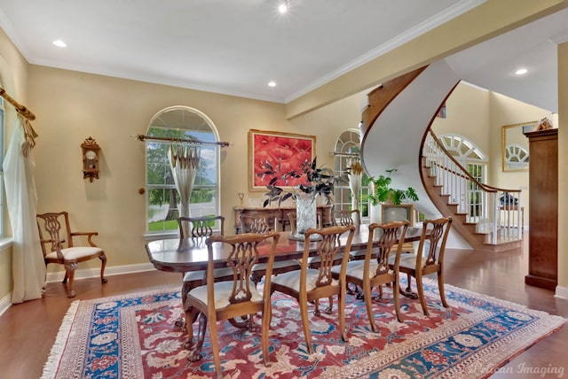 dining area featuring wood-type flooring and crown molding