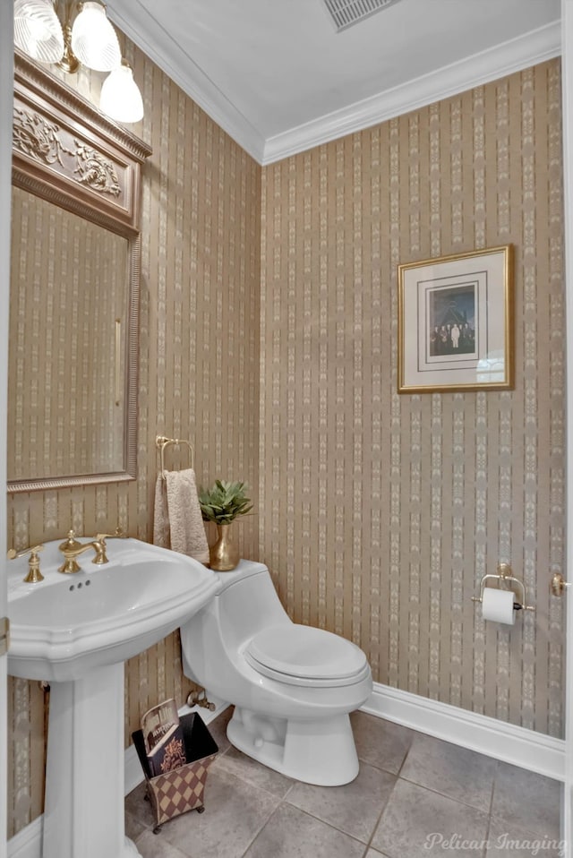 bathroom with tile patterned floors, crown molding, toilet, and sink