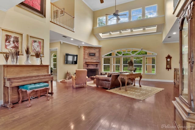 living room with hardwood / wood-style flooring, a towering ceiling, a wealth of natural light, and ceiling fan