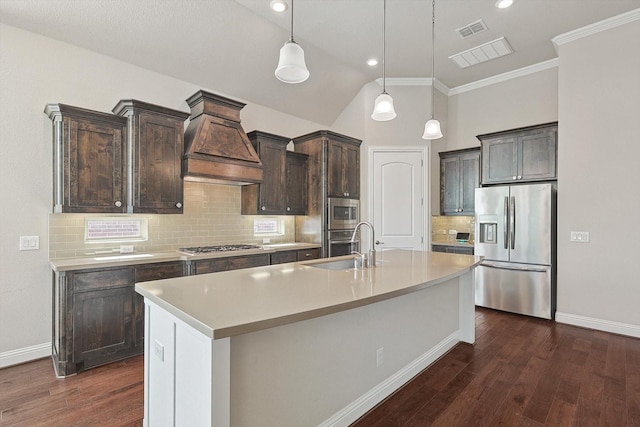 kitchen featuring dark brown cabinetry, a center island with sink, and stainless steel appliances