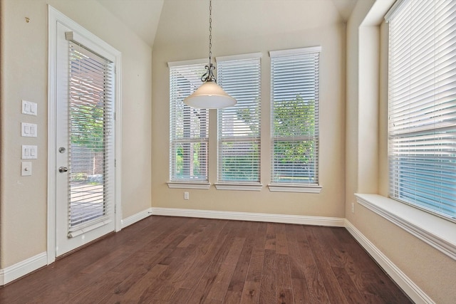 unfurnished dining area with dark hardwood / wood-style flooring and vaulted ceiling