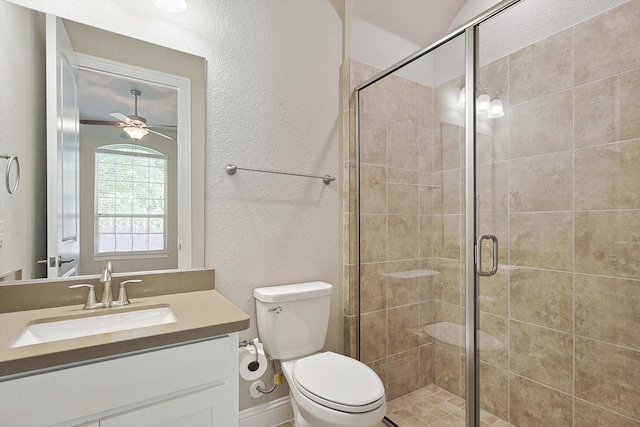 bathroom with ceiling fan, toilet, an enclosed shower, and vanity