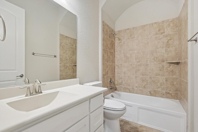 full bathroom with toilet, vanity, and tiled shower / bath