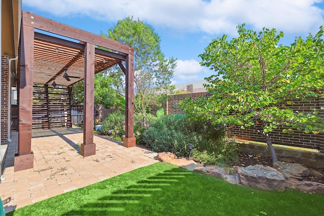 view of yard featuring a patio, ceiling fan, and a pergola