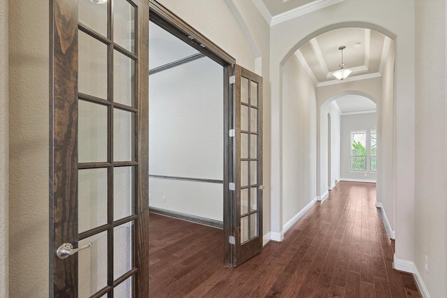 hallway with dark hardwood / wood-style floors, ornamental molding, and french doors