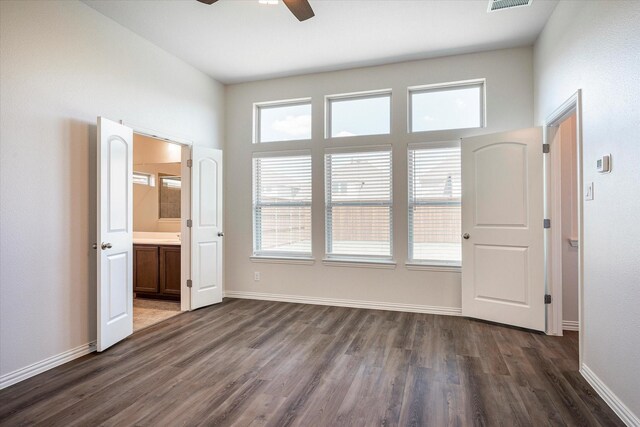 unfurnished bedroom with ensuite bathroom, ceiling fan, and wood-type flooring