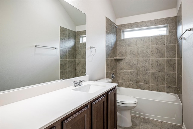 full bathroom featuring vanity, tile patterned floors, vaulted ceiling, tiled shower / bath combo, and toilet