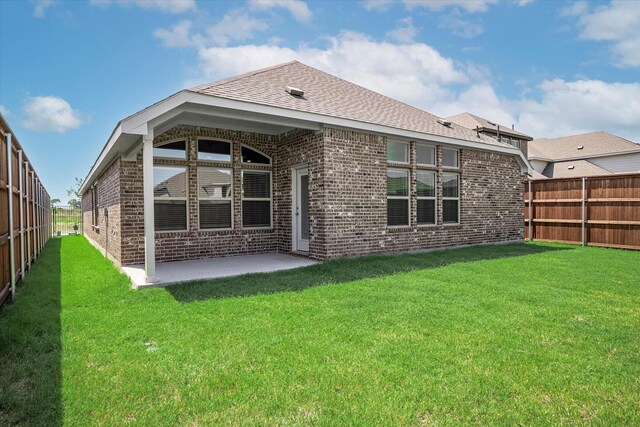 rear view of house featuring a patio and a yard