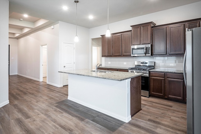 kitchen with stainless steel appliances, decorative backsplash, sink, light stone countertops, and dark wood-type flooring