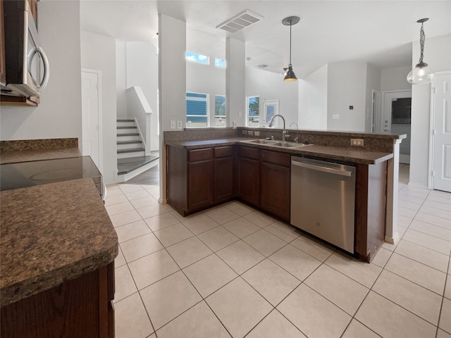 kitchen featuring light tile patterned flooring, sink, appliances with stainless steel finishes, and decorative light fixtures