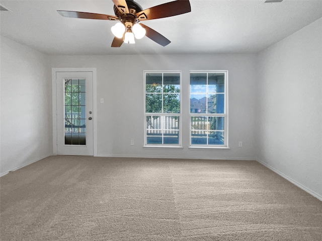 carpeted empty room featuring ceiling fan