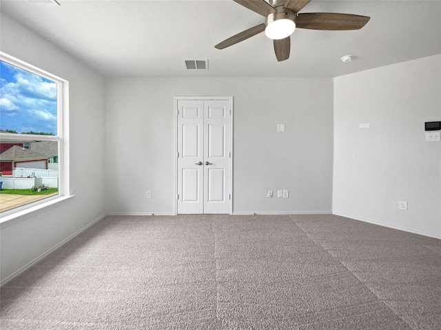 carpeted spare room featuring ceiling fan