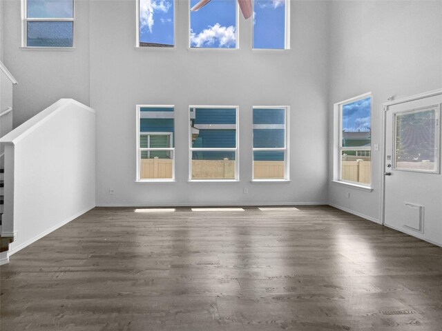 interior space featuring wood-type flooring and a towering ceiling