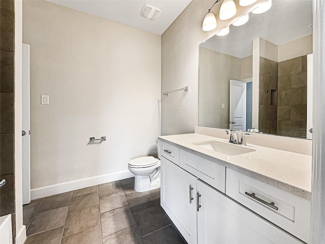 bathroom with vanity, toilet, and tiled shower