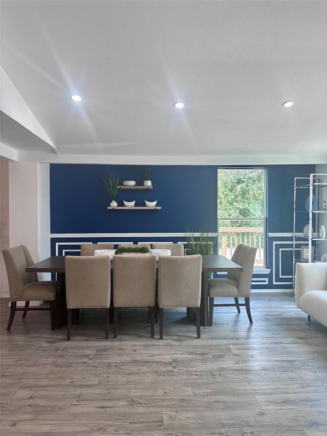 dining area with a textured ceiling and hardwood / wood-style flooring