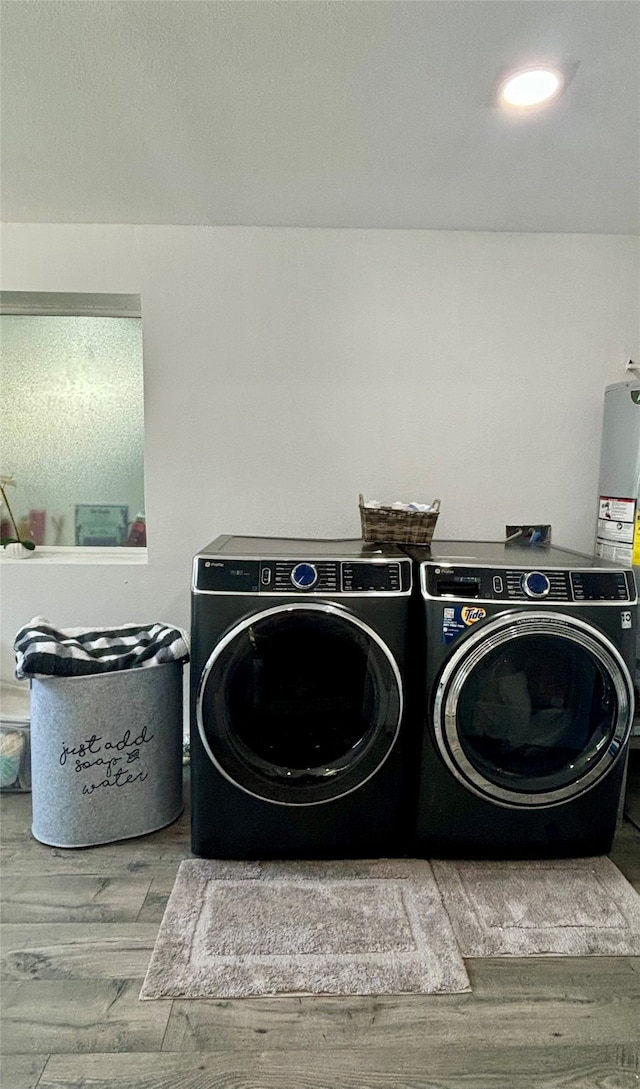 clothes washing area with light hardwood / wood-style floors and washing machine and clothes dryer