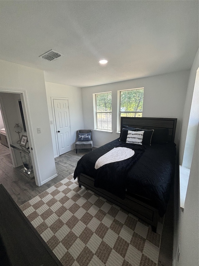 bedroom with dark hardwood / wood-style floors