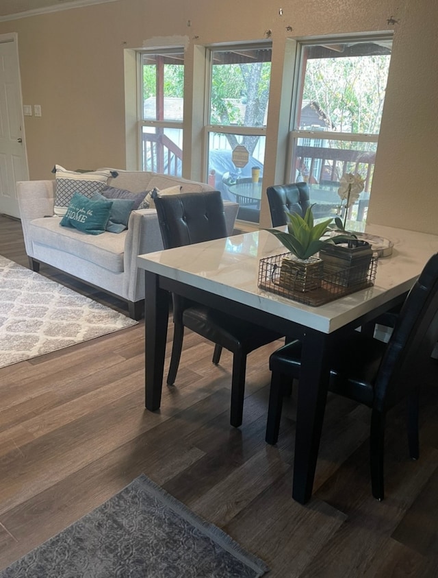 dining space featuring ornamental molding, dark wood-type flooring, and plenty of natural light