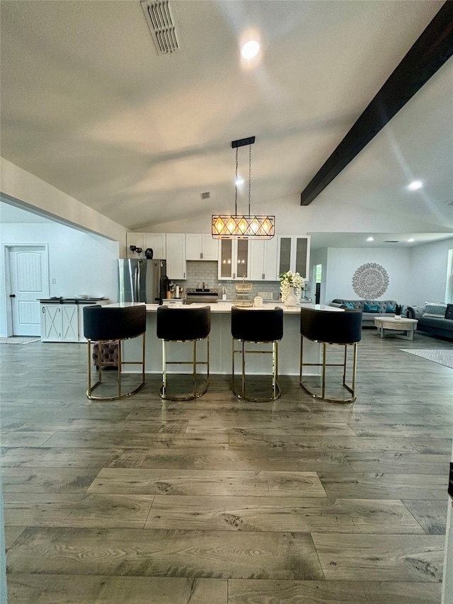 bar featuring backsplash, stainless steel fridge, decorative light fixtures, white cabinets, and hardwood / wood-style flooring