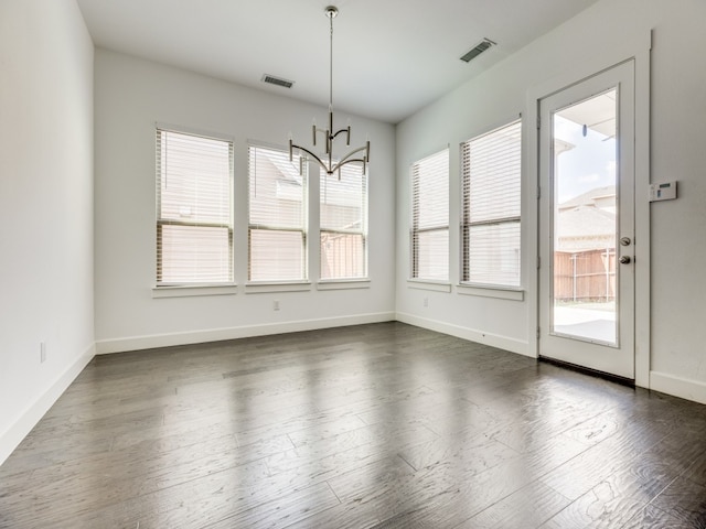 unfurnished dining area featuring dark hardwood / wood-style flooring and a chandelier