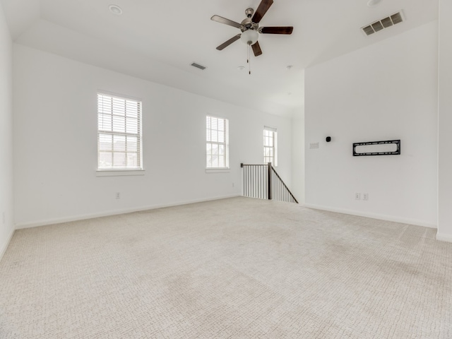 unfurnished room featuring plenty of natural light, ceiling fan, and light colored carpet