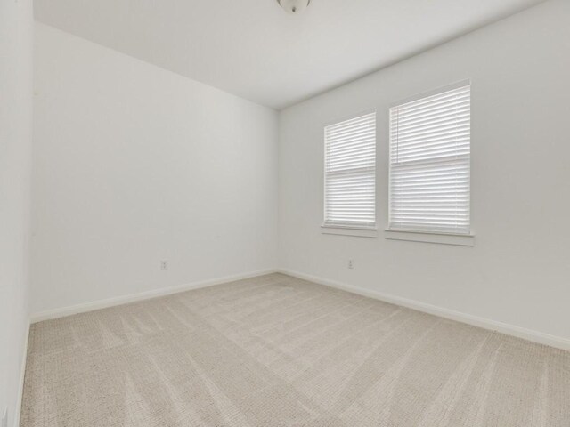 unfurnished room featuring light colored carpet