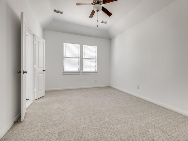 carpeted spare room featuring ceiling fan and vaulted ceiling