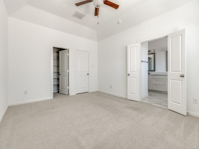 unfurnished bedroom featuring ceiling fan, connected bathroom, and light colored carpet