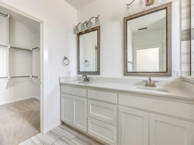 bathroom with tile patterned floors and dual bowl vanity