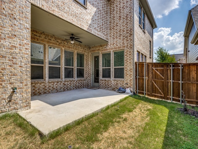 back of house featuring ceiling fan, a patio area, and a lawn