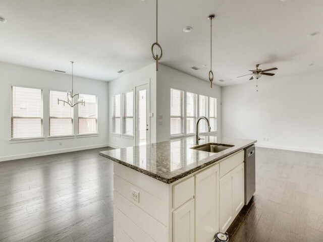 kitchen with sink, a wealth of natural light, wood-type flooring, and dark stone counters