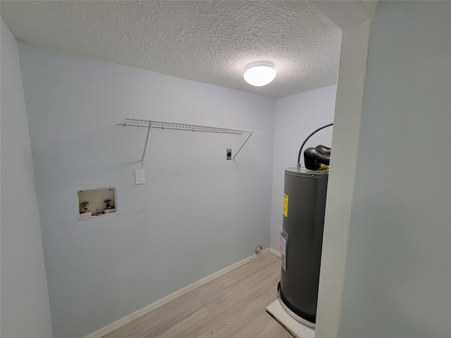 washroom featuring electric water heater, hookup for an electric dryer, light hardwood / wood-style floors, a textured ceiling, and washer hookup