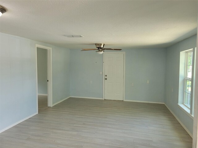 unfurnished room with a textured ceiling, ceiling fan, and light hardwood / wood-style floors