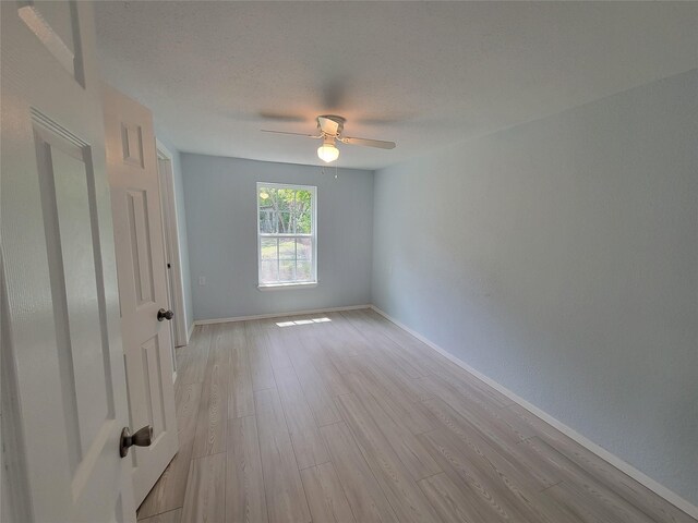 spare room featuring light hardwood / wood-style flooring, a textured ceiling, and ceiling fan