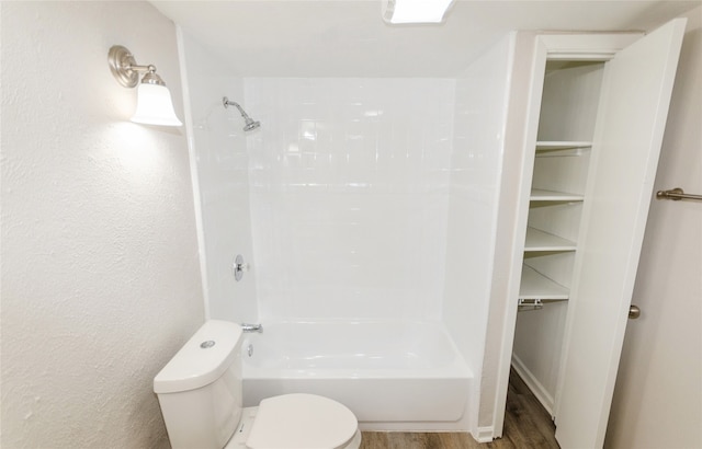 bathroom with shower / bathing tub combination, hardwood / wood-style flooring, and toilet