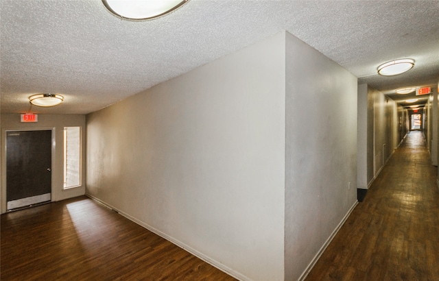 hallway featuring dark hardwood / wood-style floors and a textured ceiling