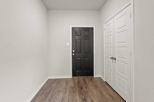 entryway with baseboards and dark wood-type flooring