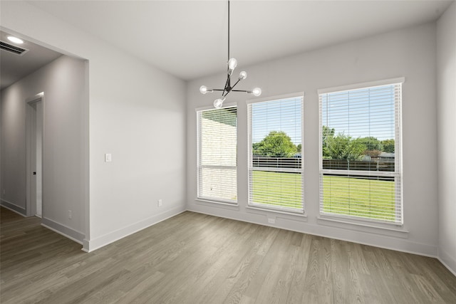 unfurnished dining area with light hardwood / wood-style flooring and an inviting chandelier