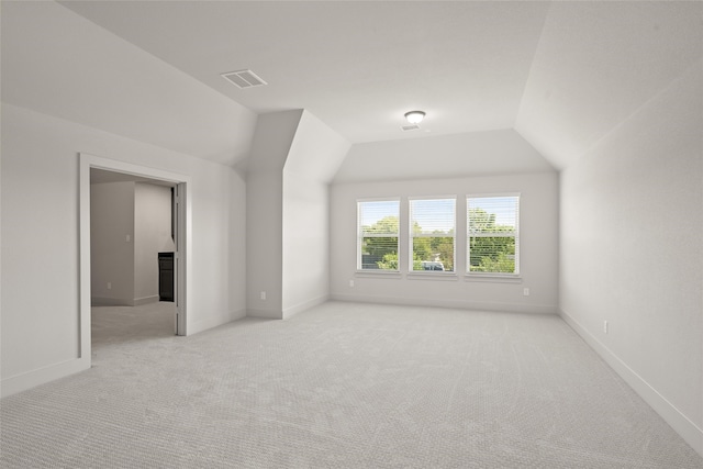 bonus room featuring light colored carpet and vaulted ceiling