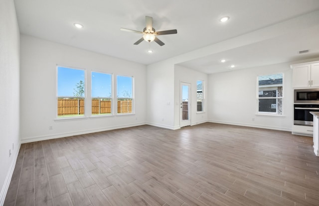 unfurnished living room with ceiling fan and light hardwood / wood-style flooring