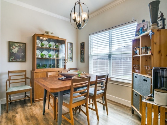 dining space featuring a notable chandelier, crown molding, and hardwood / wood-style floors