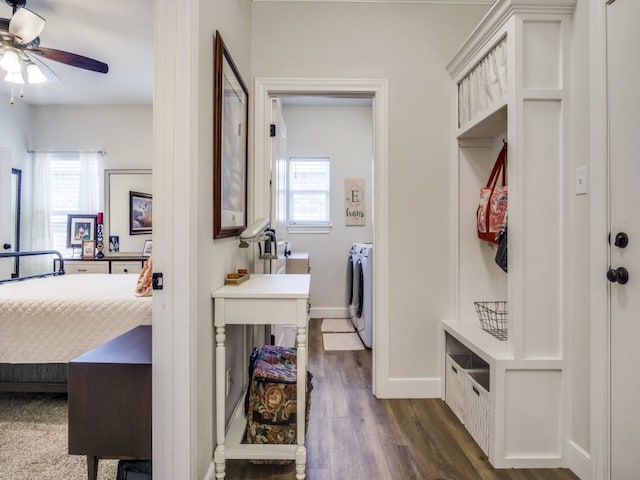 laundry area featuring washing machine and clothes dryer, ceiling fan, plenty of natural light, and dark hardwood / wood-style flooring