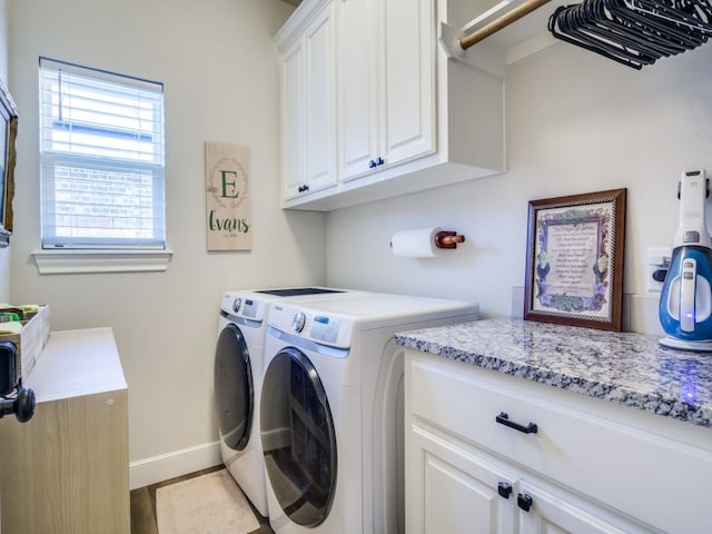 laundry area with light tile patterned flooring, washing machine and clothes dryer, and cabinets