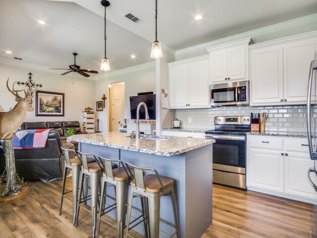 kitchen featuring white cabinetry, dark hardwood / wood-style flooring, stainless steel appliances, and backsplash