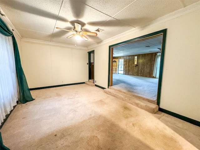 spare room featuring baseboards, carpet flooring, visible vents, and crown molding