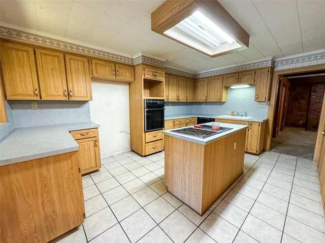 kitchen with light countertops, a kitchen island, oven, and stainless steel gas stovetop