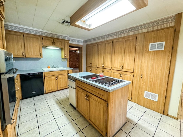 kitchen with black appliances, a kitchen island, visible vents, and light countertops