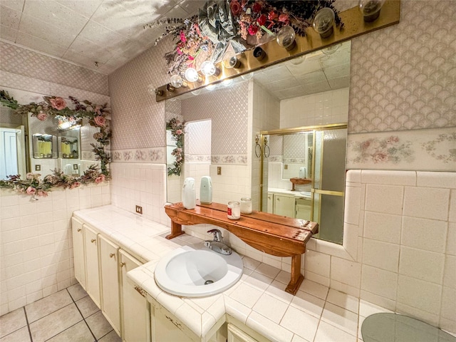 full bathroom featuring tile patterned flooring, tile walls, a shower stall, and wallpapered walls