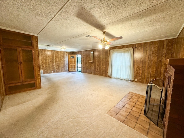 interior space featuring wood walls, a ceiling fan, and carpet flooring