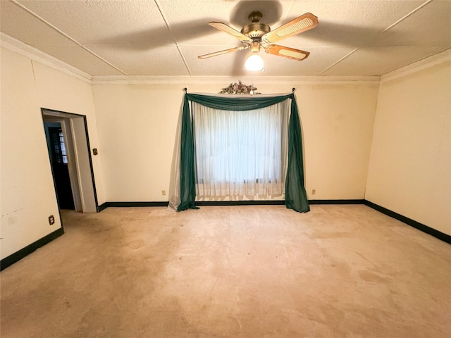 spare room with ornamental molding, light carpet, and a ceiling fan